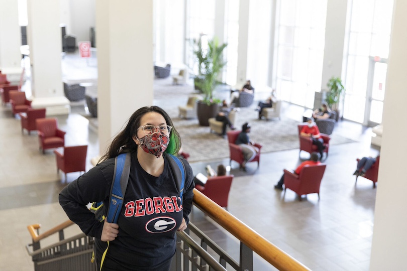 Undergraduate student Cassie Ryan walks up the stairs as students and university employees demonstrate new social distancing measures inside common areas at the Tate Student Center. (Photo by Andrew Davis Tucker/UGA)