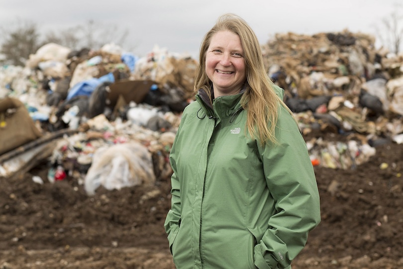 Portrait of Assistant Professor of Environmental Engineering Jenna Jambeck with trash and debris behind her on site at the Athens Clarke County Landfill.