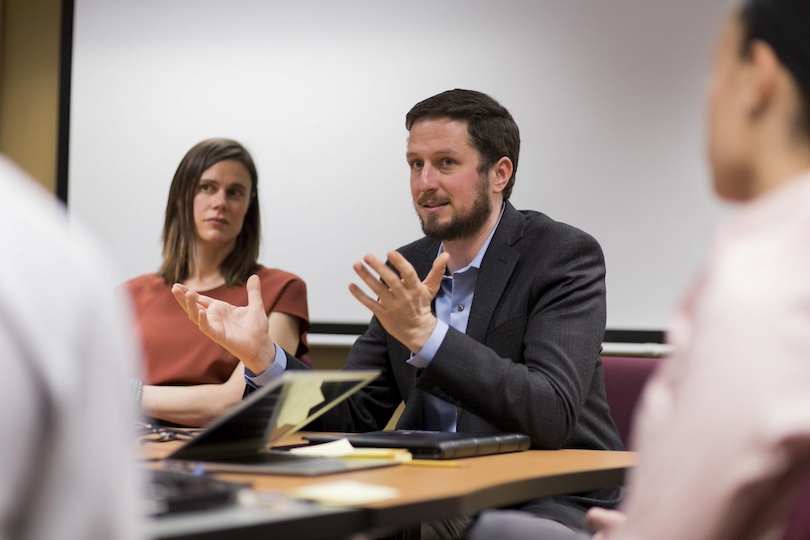 Research Scientist Dr. Nicola Sochacka, left, and associate professor Joachim Walther, right, talk with students during their CLUSTER research group meeting.