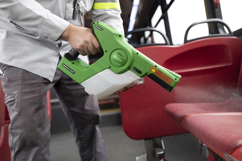 Electronics maintenance engineer supervisor Charlton Scott uses a disinfectant gun to sanitize a bus at the campus transit facility. (Photo by Andrew Davis Tucker/UGA)