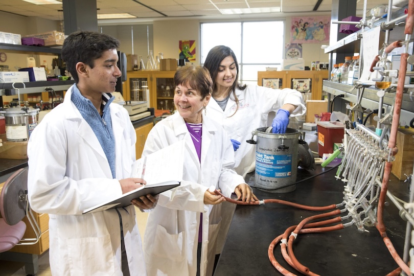 (L-R) Young Dawg student Tanishk Sinha, professor Janet Westpheling, and undergraduate student (and former Young Dawgs participant) Noor Sohal interact inside a genetics laboratory.