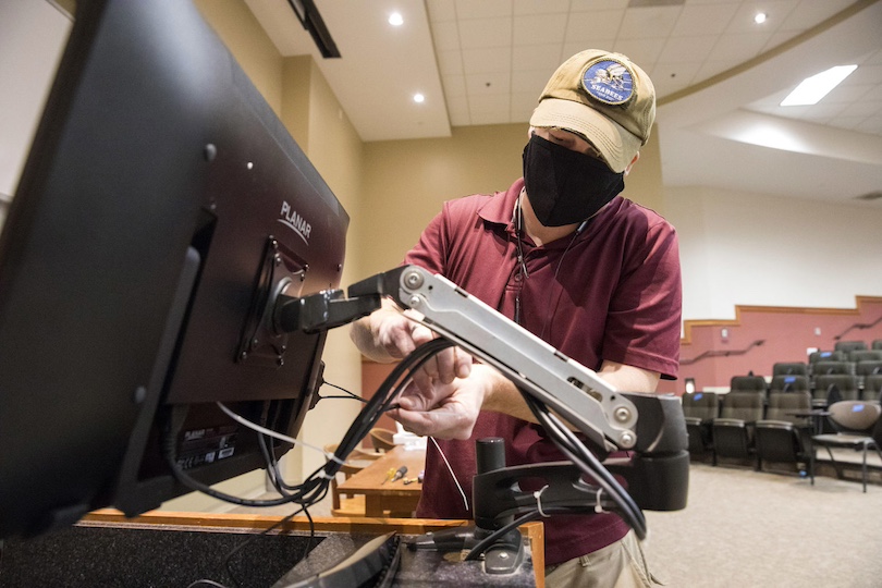 CTL Instructional Technology Systems Professional Benjy Fry installs a new monitor, complete with camera and microphone, to help facilitate lecture capture in a large classroom in the Miller Learning Center. (Photo by Dorothy Kozlowski/UGA)